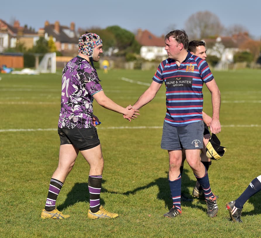 Two rugby players shaking hands in good sportsmanship