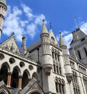 A view looking up at the Royal Courts of Justice against a bright blue sky