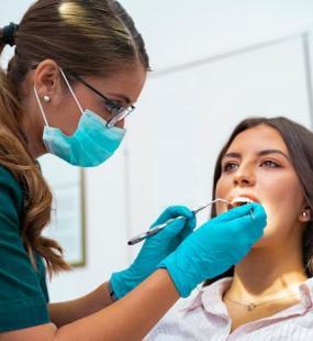 Female dentist looking into a patients mouth 