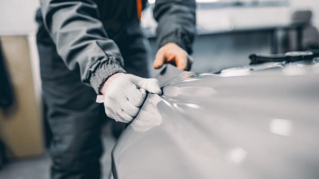 A mechanic in a garage works on a sports car