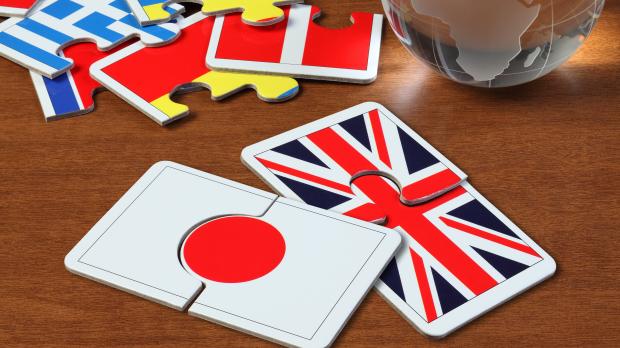 The Japanese and British flags as puzzle pieces on a wooden table