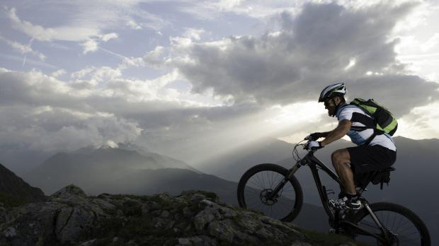 A man on a mountain bike cycles up a mountain